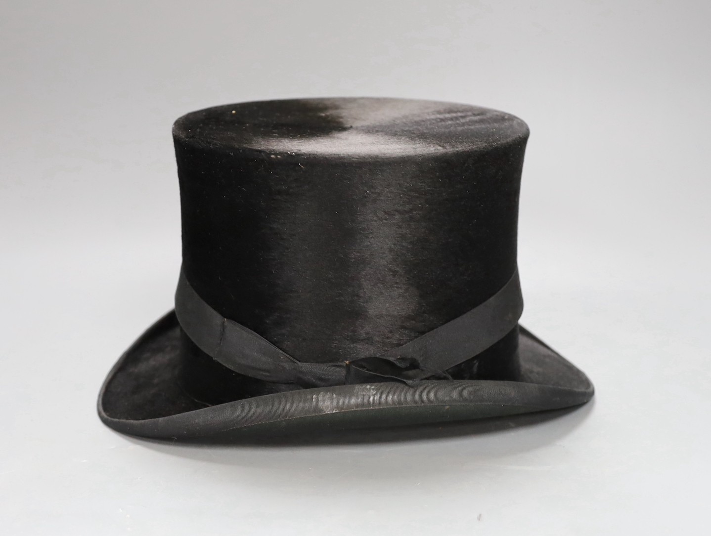A leather cased Cuthbertson top hat, 19.5x15.5cm